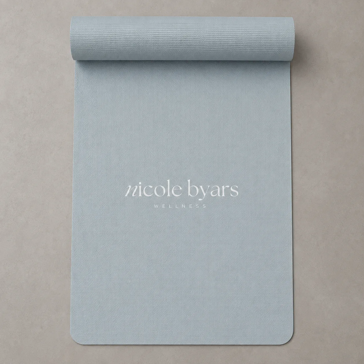 Nicole Byars Wellness yoga mat in pale blue on a warm neutral surface